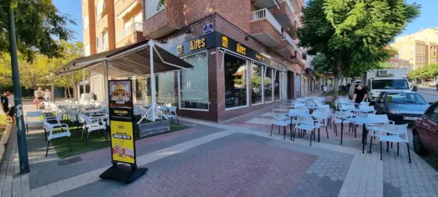 Fachada y terraza de Aires Burger Bar Crevillente en una esquina arbolada
