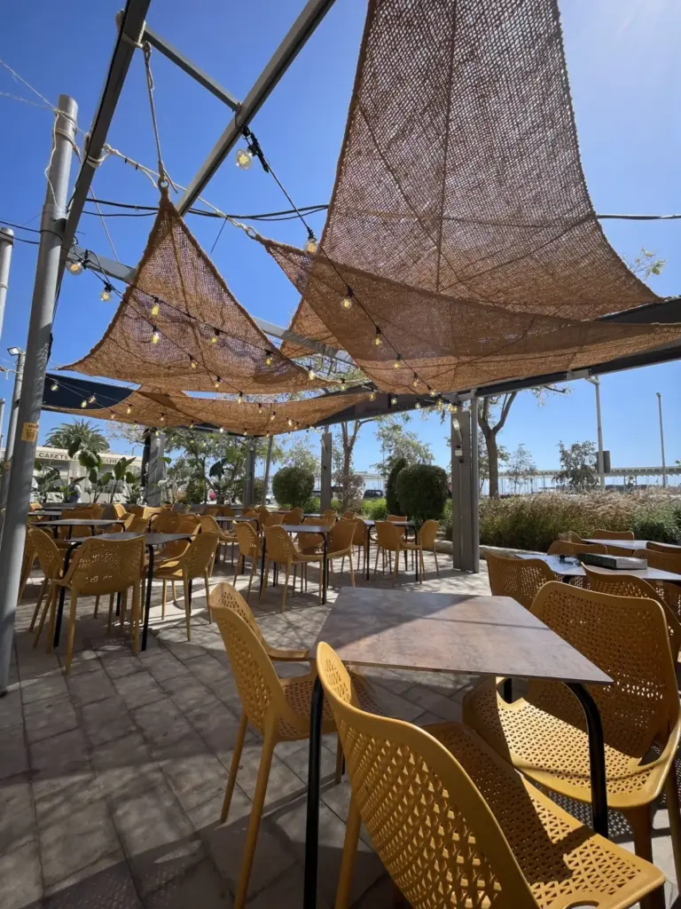 Terraza de Aires Burger Bar Santa Pola con toldos triangulares y mesas al aire libre