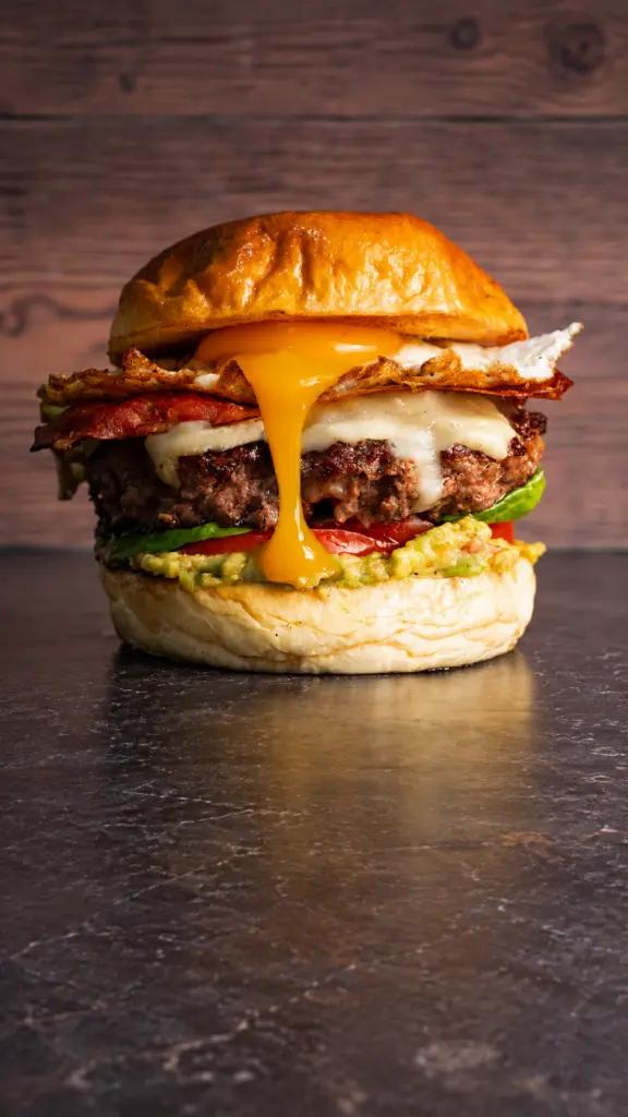 Hamburguesa 7 Pecados con queso fundido cayendo sobre la carne