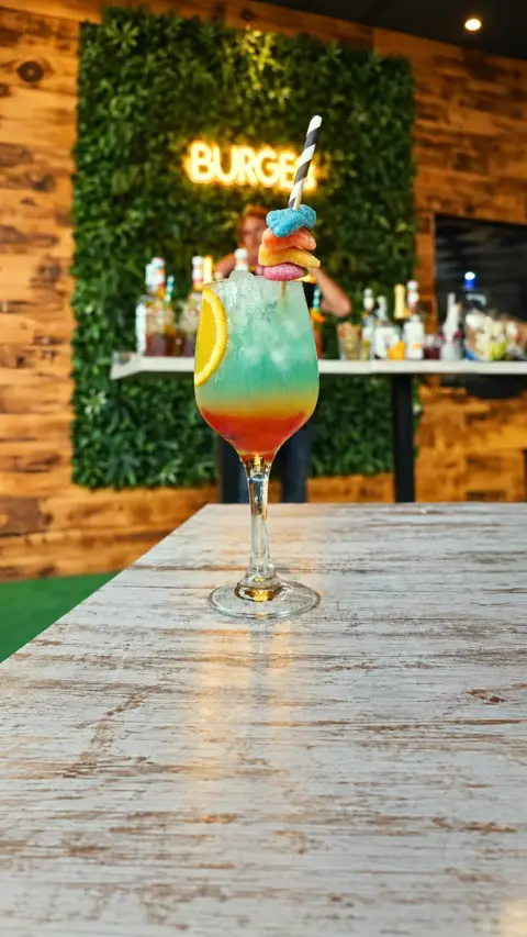 Cóctel Blue Kiss azul en una copa decorada con fruta
