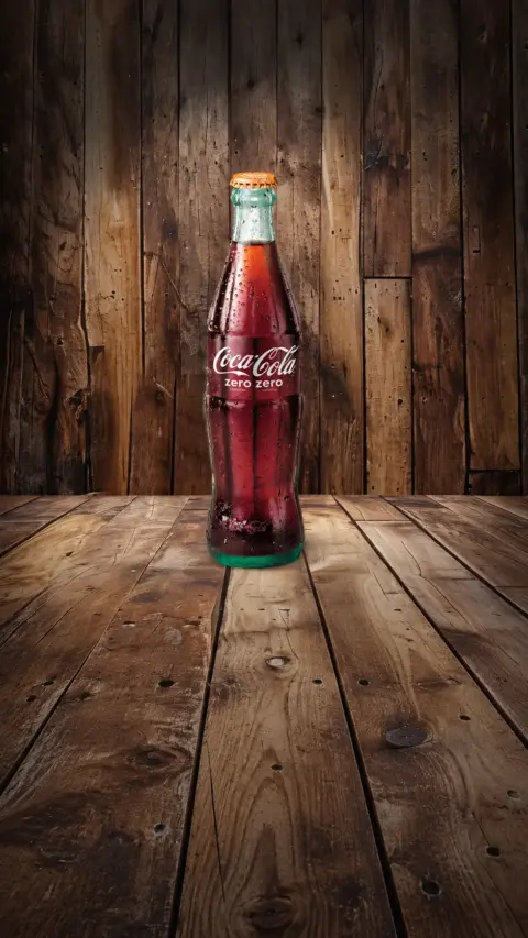 Botella de Coca-Cola con etiqueta Zero sobre fondo de madera