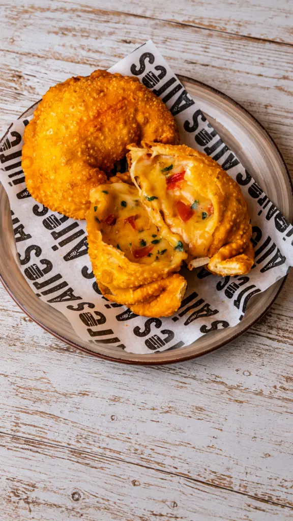 Empanada Capresse abierta junto a otra empanada entera