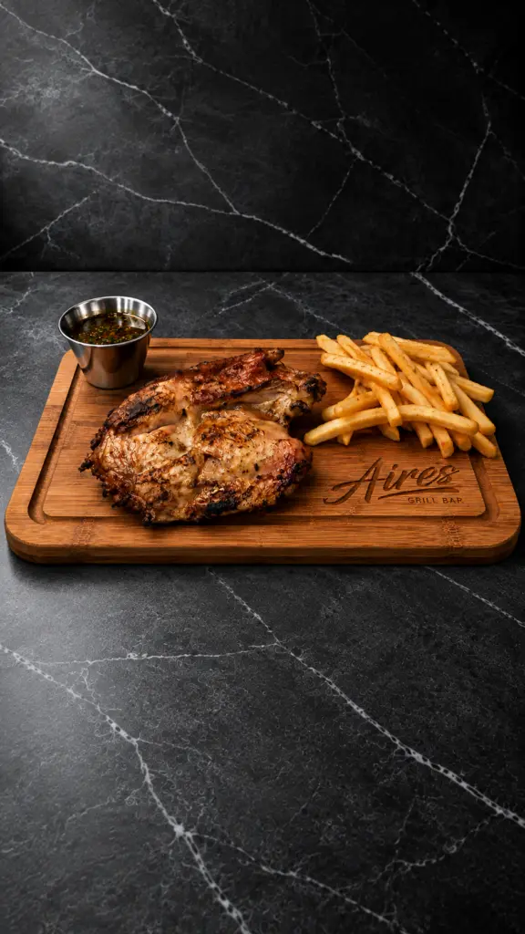 Pollo deshuesado a la brasa con patatas fritas sobre una tabla