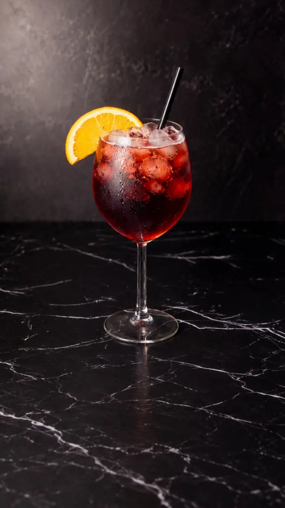 Copa de tinto de verano con hielo y rodaja de naranja